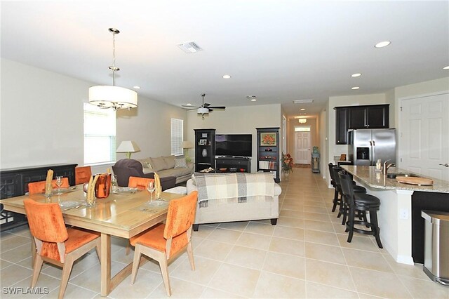 dining room with ceiling fan, light tile patterned flooring, and sink