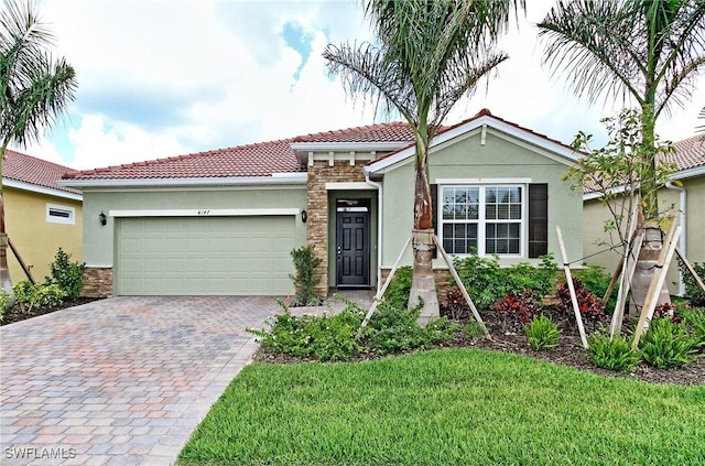 view of front of property with a garage, a tile roof, stone siding, decorative driveway, and stucco siding