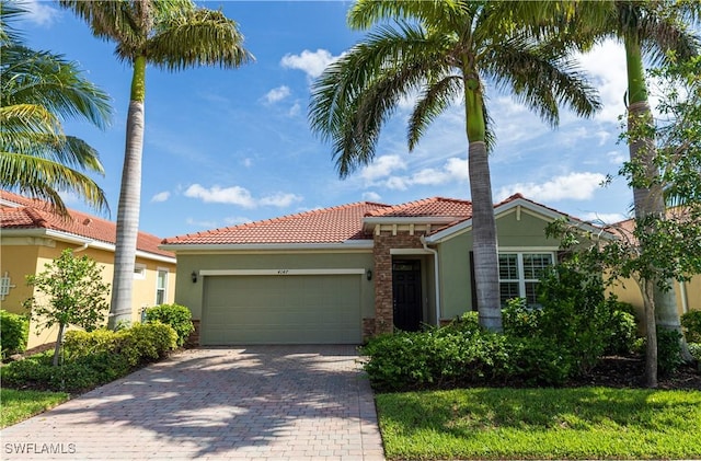 4147 Dutchess Park Rd, Fort Myers, FL 33916 - mediterranean / spanish-style home featuring stucco siding, a tile roof, a garage, and decorative driveway