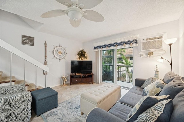 living room featuring a wall unit AC, ceiling fan, light tile patterned floors, and a textured ceiling