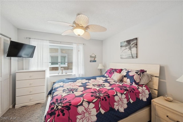 bedroom with carpet, a textured ceiling, and ceiling fan