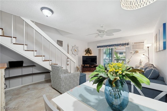 dining area featuring ceiling fan, an AC wall unit, and a textured ceiling