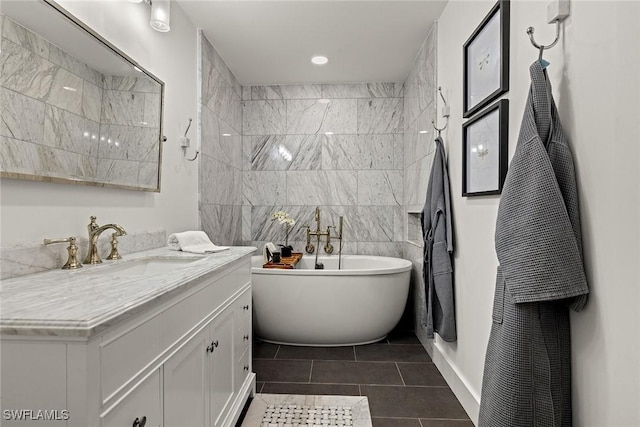 bathroom featuring a soaking tub, tile patterned flooring, vanity, and tile walls