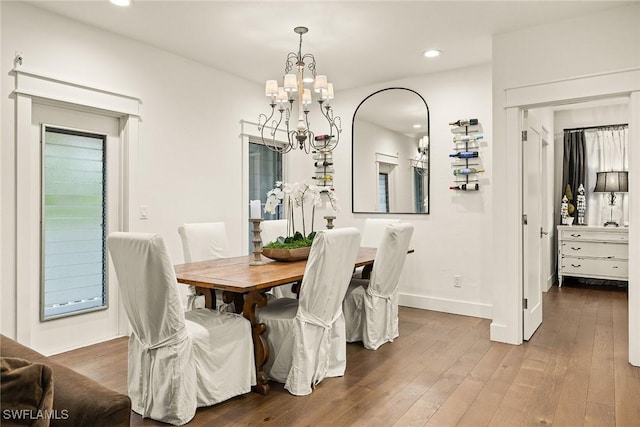 dining space featuring recessed lighting, baseboards, an inviting chandelier, and hardwood / wood-style flooring