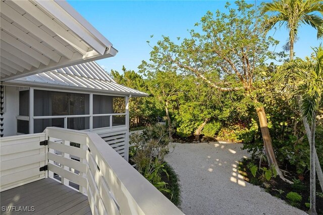 view of side of property featuring a standing seam roof, metal roof, and a sunroom