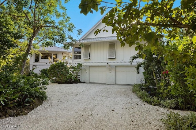 view of front of home with metal roof, driveway, and an attached garage