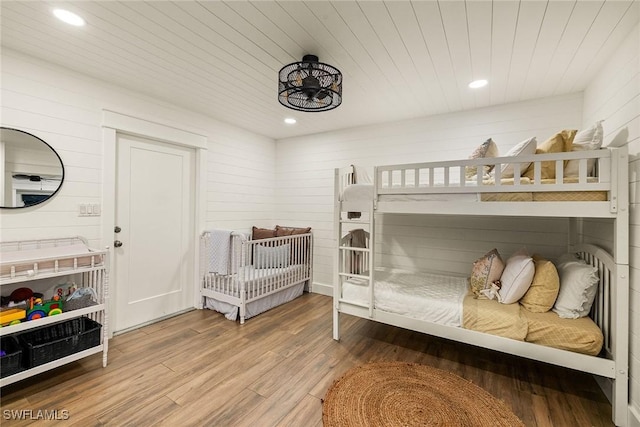 bedroom featuring recessed lighting, wooden ceiling, wood finished floors, and wooden walls