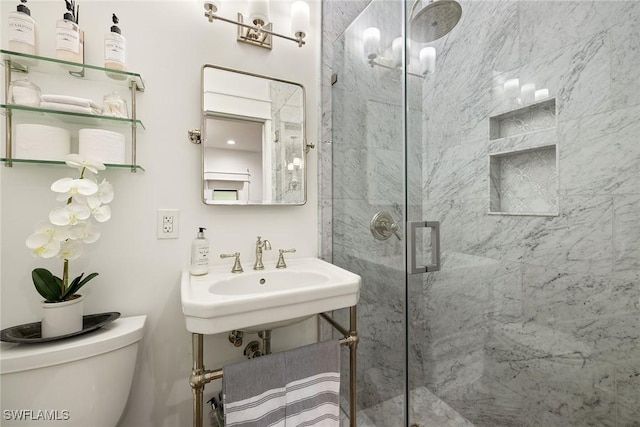 bathroom with a marble finish shower and toilet