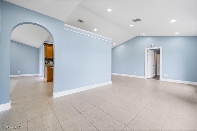 tiled spare room with lofted ceiling