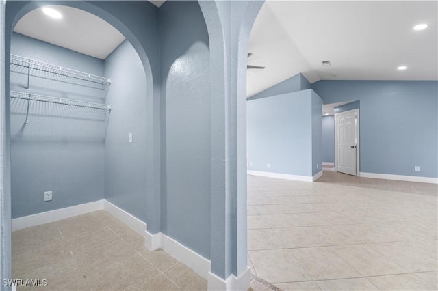 interior space with light tile patterned floors and lofted ceiling