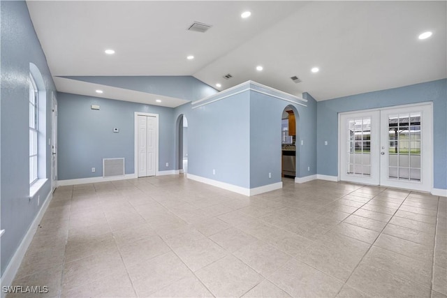 unfurnished room featuring lofted ceiling, light tile patterned floors, and french doors