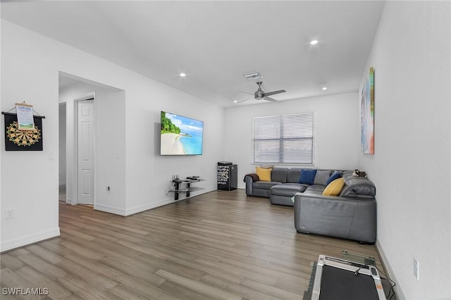 living room featuring ceiling fan and light hardwood / wood-style flooring