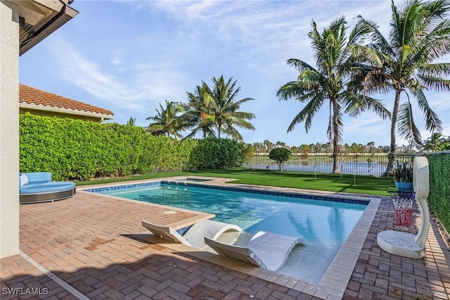 view of swimming pool with a water view, a yard, and a patio area