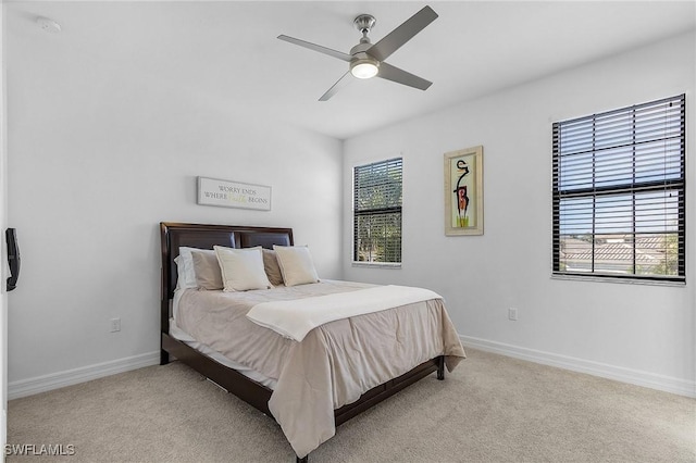 carpeted bedroom with multiple windows and ceiling fan