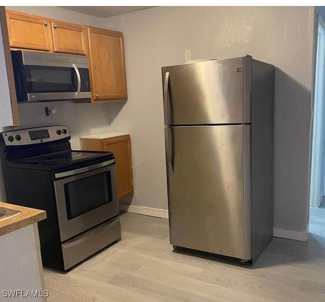 kitchen featuring appliances with stainless steel finishes and light hardwood / wood-style floors