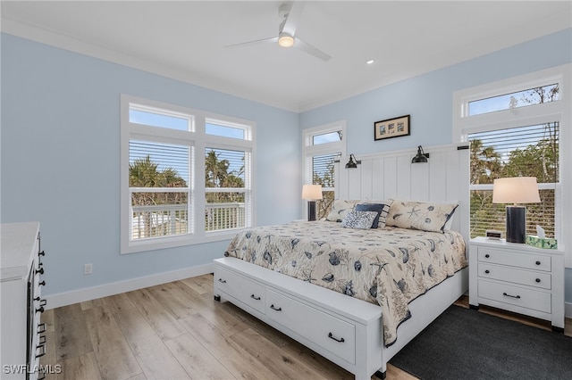 bedroom featuring multiple windows, light wood-type flooring, ceiling fan, and crown molding