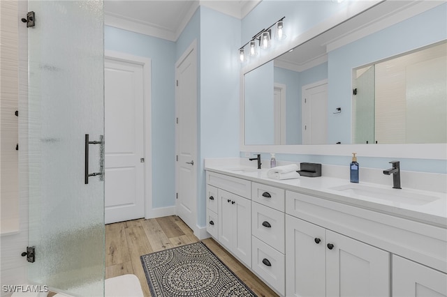 bathroom with crown molding, hardwood / wood-style floors, vanity, and walk in shower