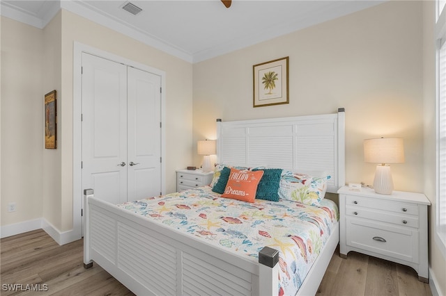 bedroom with light hardwood / wood-style flooring, a closet, and ornamental molding