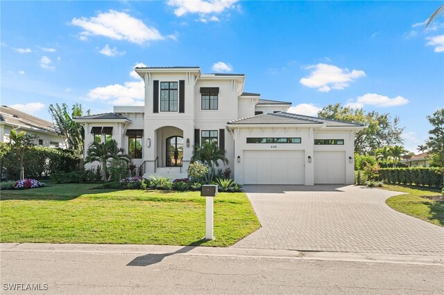 view of front of home with a garage and a front lawn