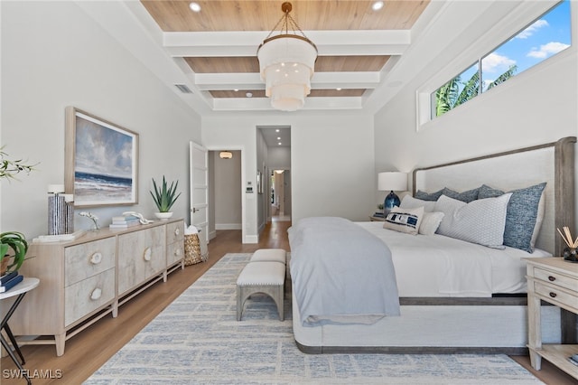 bedroom featuring beamed ceiling, wood-type flooring, and coffered ceiling