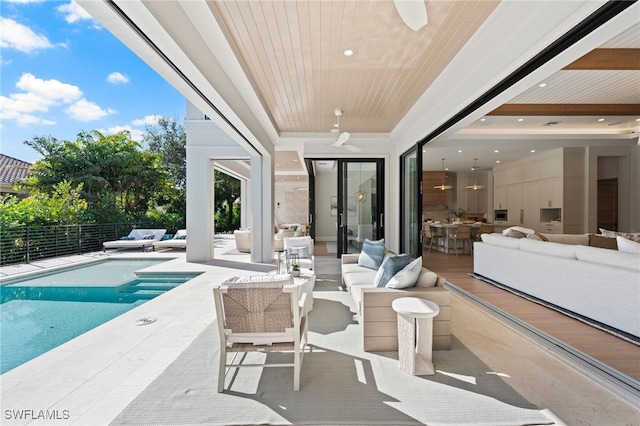 view of patio / terrace featuring ceiling fan, an outdoor living space, and a fenced in pool