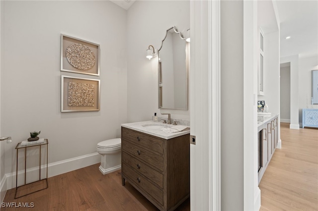 bathroom featuring vanity, hardwood / wood-style flooring, and toilet