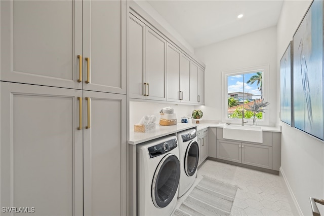 washroom with washer and dryer, sink, and cabinets