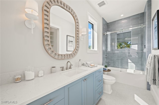 full bathroom featuring enclosed tub / shower combo, vanity, and toilet