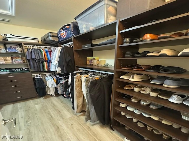 walk in closet with light wood-type flooring