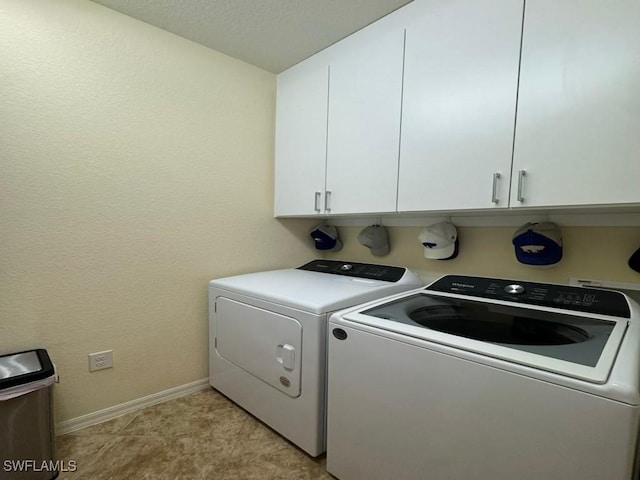 laundry area with cabinets and washer and clothes dryer