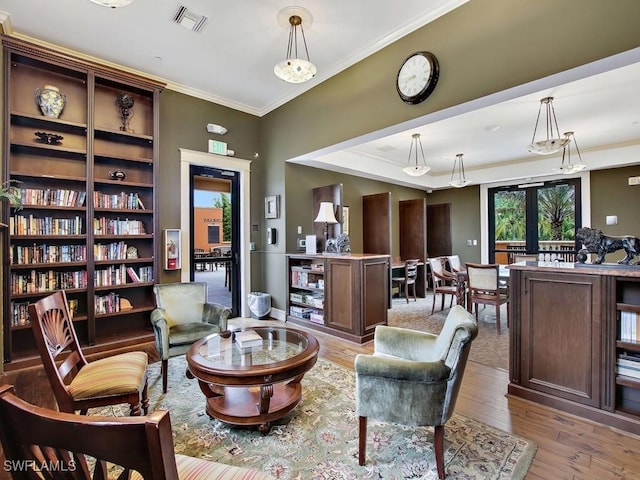 sitting room featuring crown molding, light wood-type flooring, and french doors