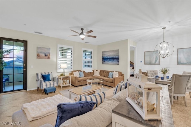 living room featuring ceiling fan with notable chandelier, a healthy amount of sunlight, and light tile patterned flooring