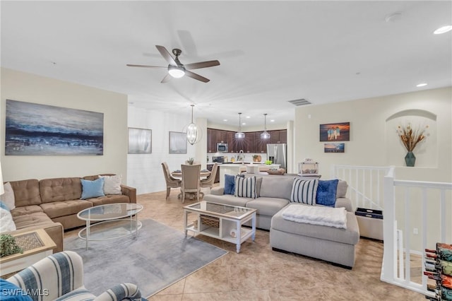 living room with sink, light tile patterned floors, and ceiling fan