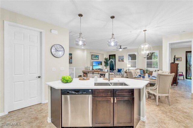 kitchen featuring dark brown cabinetry, decorative light fixtures, sink, and a center island with sink