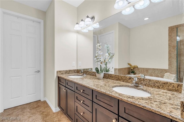 bathroom with vanity, tile patterned flooring, and a tub