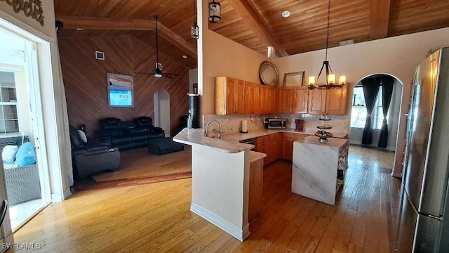 kitchen featuring kitchen peninsula, appliances with stainless steel finishes, wood ceiling, high vaulted ceiling, and light hardwood / wood-style floors