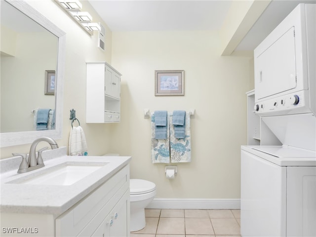 bathroom featuring tile patterned floors, vanity, stacked washing maching and dryer, and toilet