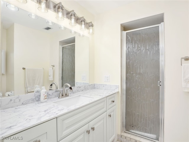 bathroom with vanity and a shower with shower door