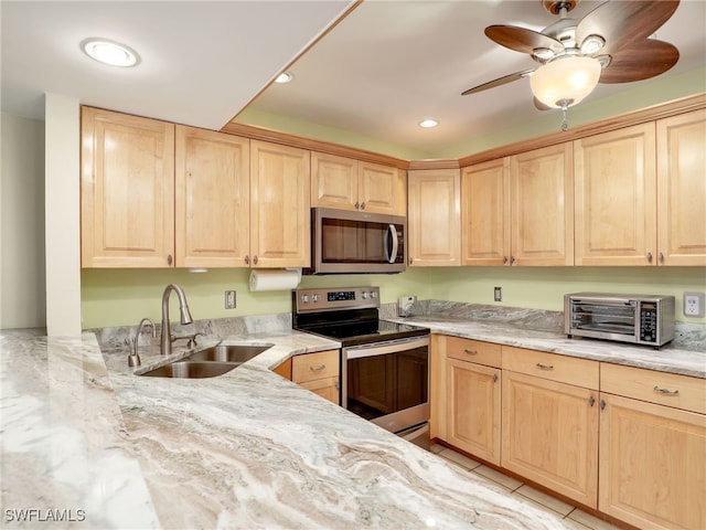 kitchen featuring ceiling fan, light stone countertops, sink, and appliances with stainless steel finishes