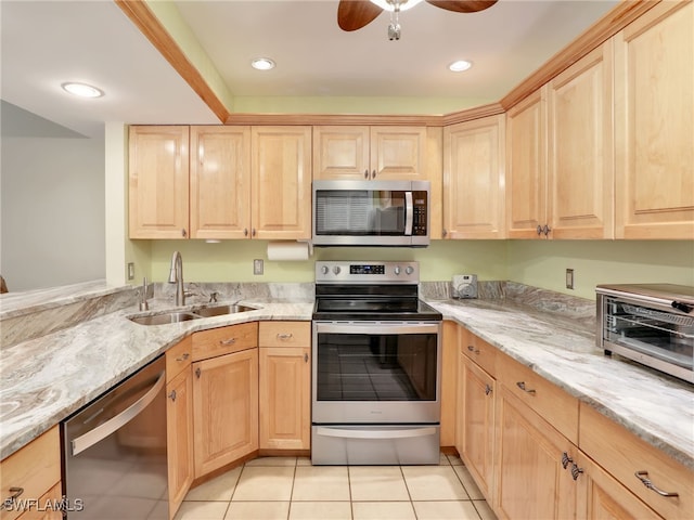 kitchen featuring light stone countertops, sink, light brown cabinetry, light tile patterned flooring, and appliances with stainless steel finishes