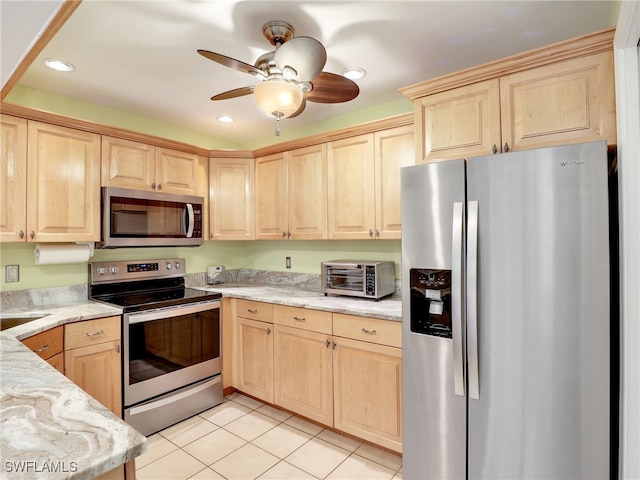 kitchen featuring light brown cabinets, ceiling fan, light stone countertops, light tile patterned floors, and appliances with stainless steel finishes