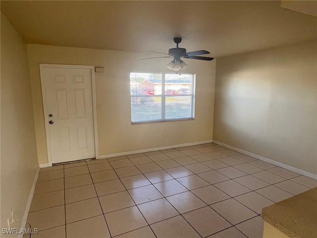 spare room with ceiling fan and light tile patterned floors