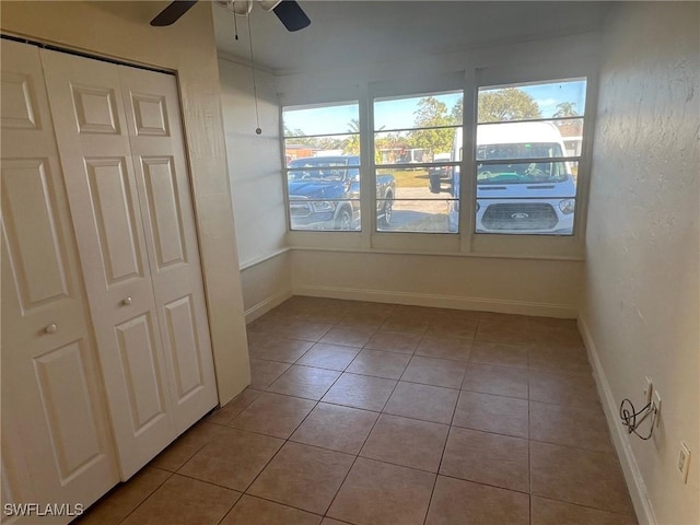 unfurnished sunroom featuring ceiling fan