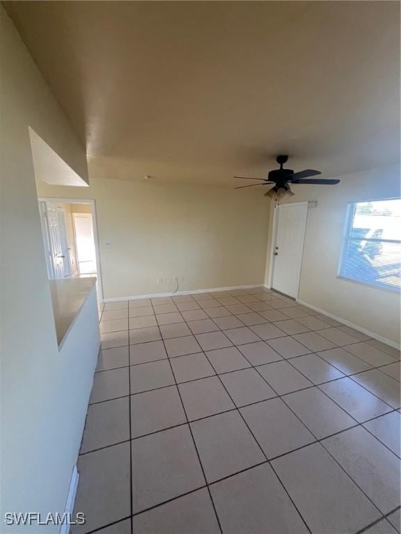 tiled empty room featuring ceiling fan