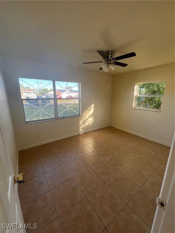 unfurnished room with ceiling fan, plenty of natural light, and light tile patterned floors