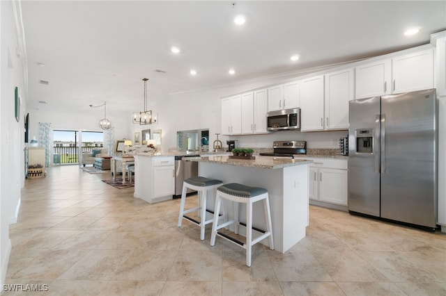 kitchen with pendant lighting, stainless steel appliances, and white cabinetry