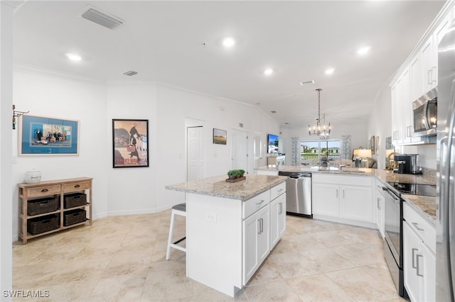 kitchen featuring kitchen peninsula, light stone countertops, appliances with stainless steel finishes, a kitchen island, and white cabinetry