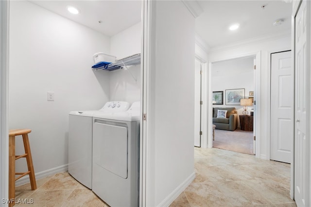 clothes washing area with crown molding and washer and clothes dryer