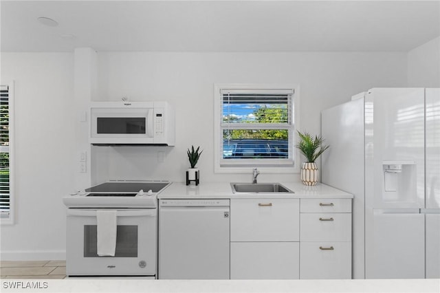 kitchen with white cabinetry, sink, and white appliances