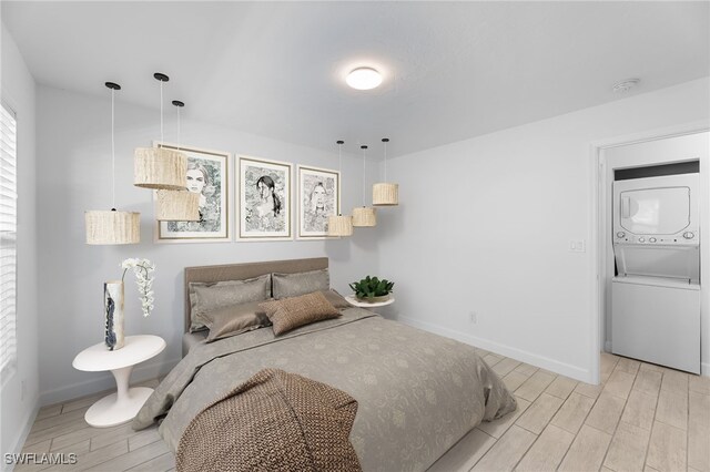 2722 Arbutus St Unit C2, Naples, FL 34112 - bedroom with stacked washer / dryer, wood tiled floors, and baseboards